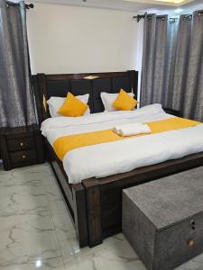 une chambre avec un grand lit avec des oreillers jaunes dans l'établissement twin paradise homes, à Nairobi