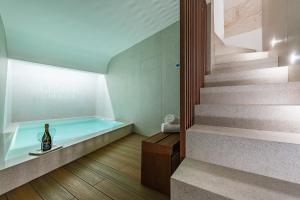 een badkuip met een fles wijn naast een trap bij Casalis Luxury Room in Ostuni
