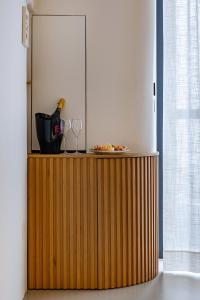 een houten kast met glazen en een fles wijn bij Casalis Luxury Room in Ostuni