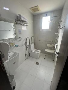 a white bathroom with a sink and a toilet at العييري ريزيدنس in Dammam