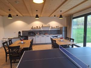 une salle à manger avec des tables de ping-pong et une cuisine dans l'établissement Chalupa U Krtka, à Bělá pod Pradědem