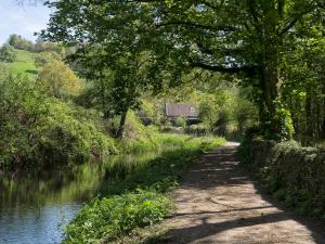 a path next to a river with a building in the distance at Nightingale Cottage - Ukc1570 in Crich