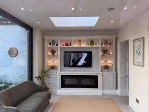 ein Wohnzimmer mit einem TV und einem Kamin in der Unterkunft Cashel Regency Townhouse in Cashel