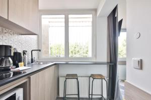 eine Küche mit zwei Hockern in einer Küche mit einem Fenster in der Unterkunft Louis Vicat 4 - CI - Apartment for 2 Parc Expo Porte de Versailles in Paris