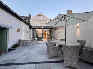 卡舍尔Cashel Regency Townhouse的天井配有桌椅和遮阳伞