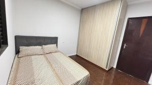 - une chambre avec un lit dans une pièce avec une porte dans l'établissement Casa ampla próxima ao centro, à Dourados