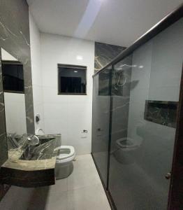 une salle de bain avec toilettes, lavabo et douche dans l'établissement Casa ampla próxima ao centro, à Dourados