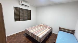 une chambre avec un lit et une fenêtre dans l'établissement Casa ampla próxima ao centro, à Dourados 13 autres photos