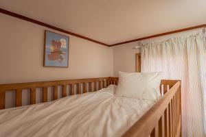 a bedroom with a bed with white sheets and a window at 온유재스테이 N seoul tower 800m in Seoul