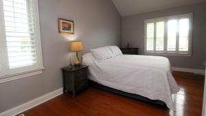 a bedroom with a bed with a lamp and two windows at Family Tides in Cape May