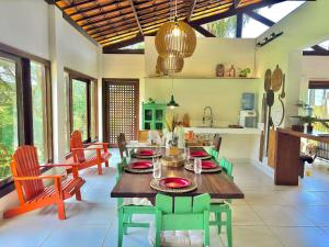 eine Küche und ein Esszimmer mit Tisch und Stühlen in der Unterkunft Vila Bambu – by Refúgio Hospedagens in Areia + 35 Fotos