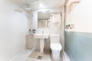 a white bathroom with a sink and a toilet at 스테이쉼 발산 in Seoul