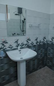 un lavandino bianco in un bagno con uno specchio di Moon&Back Homestay a Galle