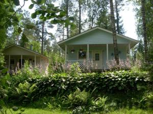 un chalet dans les bois avec des fleurs violettes dans l'établissement Juhlamenot Oy, à Söderkulla 11 autres photos