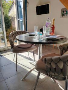 a dining table and chairs in a living room at La Suite 27 bis, maison de charme avec terrasse, proche gare et centre in Guingamp