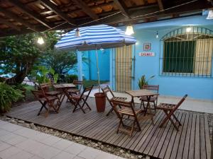 a wooden deck with a table and chairs and an umbrella at Hostel Ariramba in Mosqueiro