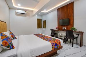 a bedroom with a bed and a desk with a computer at FabHotel New 7 Star in Mumbai