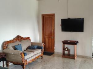 迈索尔Blue Moon Homestay的配有椅子和平板电视的客厅