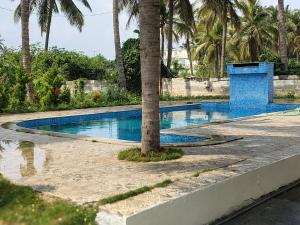 迈索尔Blue Moon Homestay的中间有一个棕榈树游泳池