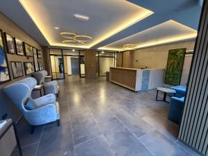 a lobby with blue chairs and a reception desk at Alpina Lux in Kopaonik +41 photos