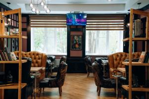 a room with chairs and tables and windows at Hotel Dastan Aktobe in Aktobe