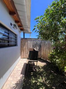 a chair sitting on a patio next to a fence at Hospedaje a 2 cuadras de la playa Mar de Cobo in Mar de Cobo