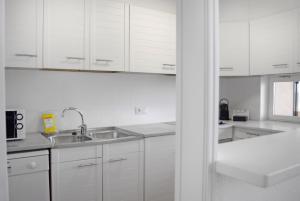 a white kitchen with white cabinets and a sink at Apartamentos Golf Mar I & II by La Costa Resort in Pals +33 photos