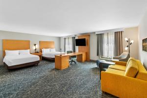 a hotel room with two beds and a couch at Hampton Inn Texarkana in Texarkana