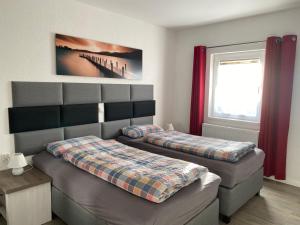 deux lits dans une chambre avec des rideaux rouges dans l'établissement Race & Rest Apartments, à Baar