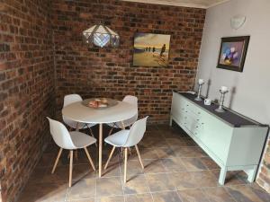 a dining room with a table and chairs and a brick wall at La Dolce Vita in Pearly Beach