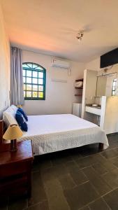 ein Schlafzimmer mit einem großen weißen Bett und einem Fenster in der Unterkunft Pousada in Bombinhas
