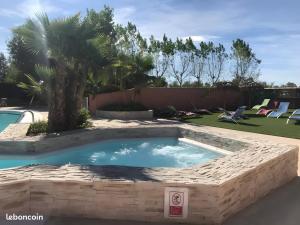 ein Pool mit einer Palme in einem Garten in der Unterkunft Location Mobilhome Agde in Agde
