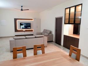 ein Wohnzimmer mit Sofa und Fernseher in der Unterkunft Amaira Studio living - Coimbatore in Coimbatore + 5 Fotos