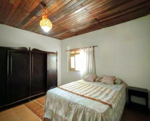 ein Schlafzimmer mit einem Bett und einer Holzdecke in der Unterkunft Sítio Bela Vista in Maceió