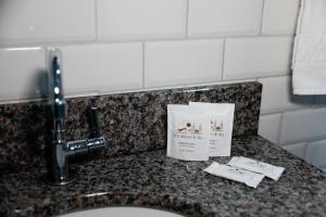 a sink in a bathroom with a sign on it at Pousada Encantos de Itá in Itá
