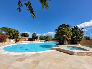 ein Swimmingpool in einem Garten mit Palmen in der Unterkunft Location Mobilhome Agde in Agde