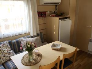 een kleine kamer met een tafel en een bank en een tafel en een tafel bij Location Mobilhome Agde in Agde