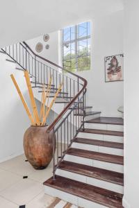 a staircase in a house with a large vase at Domaine Harmonia - Group Retreat by Sealodge Mauritius in Rivière Noire +46 photos
