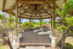 an outdoor patio with a wooden pergola at Domaine Harmonia - Group Retreat by Sealodge Mauritius in Rivière Noire