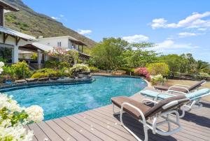 a swimming pool with chairs and a house at Domaine Harmonia - Group Retreat by Sealodge Mauritius in Rivière Noire
