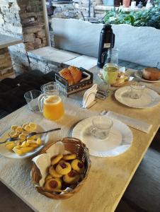 einen Tisch mit Brotplatten und Orangensaft in der Unterkunft Pousada do Luar in São Thomé das Letras