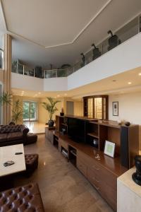 ein großes Wohnzimmer mit einem Sofa und einem TV in der Unterkunft închiriere vilă pentru evenimente, petreceri, team building, sejururi, buftea in Buftea + 61 Fotos