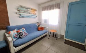 a blue couch in a room with a window at Agulhas Stay in Agulhas +18 photos