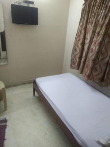 钦奈Thangam Balaji guest house-Teynampet的一间带床和电视的小卧室