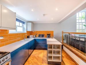 a kitchen with blue cabinets and a counter top at Hillside - Uk48202 in Stockbury +17 photos