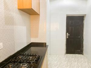 eine Küche mit einem Herd und einer schwarzen Tür in der Unterkunft Oystershell Apartments in Gbogije + 17 Fotos