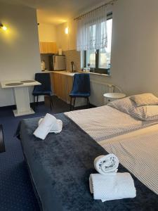 a hotel room with two beds and two chairs at Apartamenty Maria in Ciechocinek