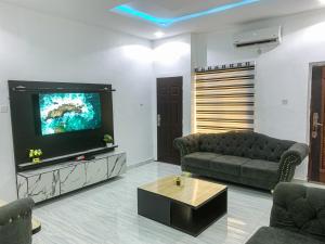 ein Wohnzimmer mit Couch und Flachbildfernseher in der Unterkunft Oystershell Apartments in Gbogije