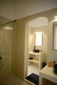 ein Badezimmer mit Dusche, Waschbecken und Spiegel in der Unterkunft The endless blue experience in Chora, Ios