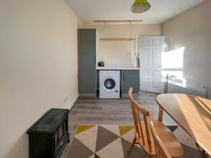 eine Küche mit einem Tisch und einer Waschmaschine in der Unterkunft Ballygroggan Cottage - Uk48768 in Machrihanish